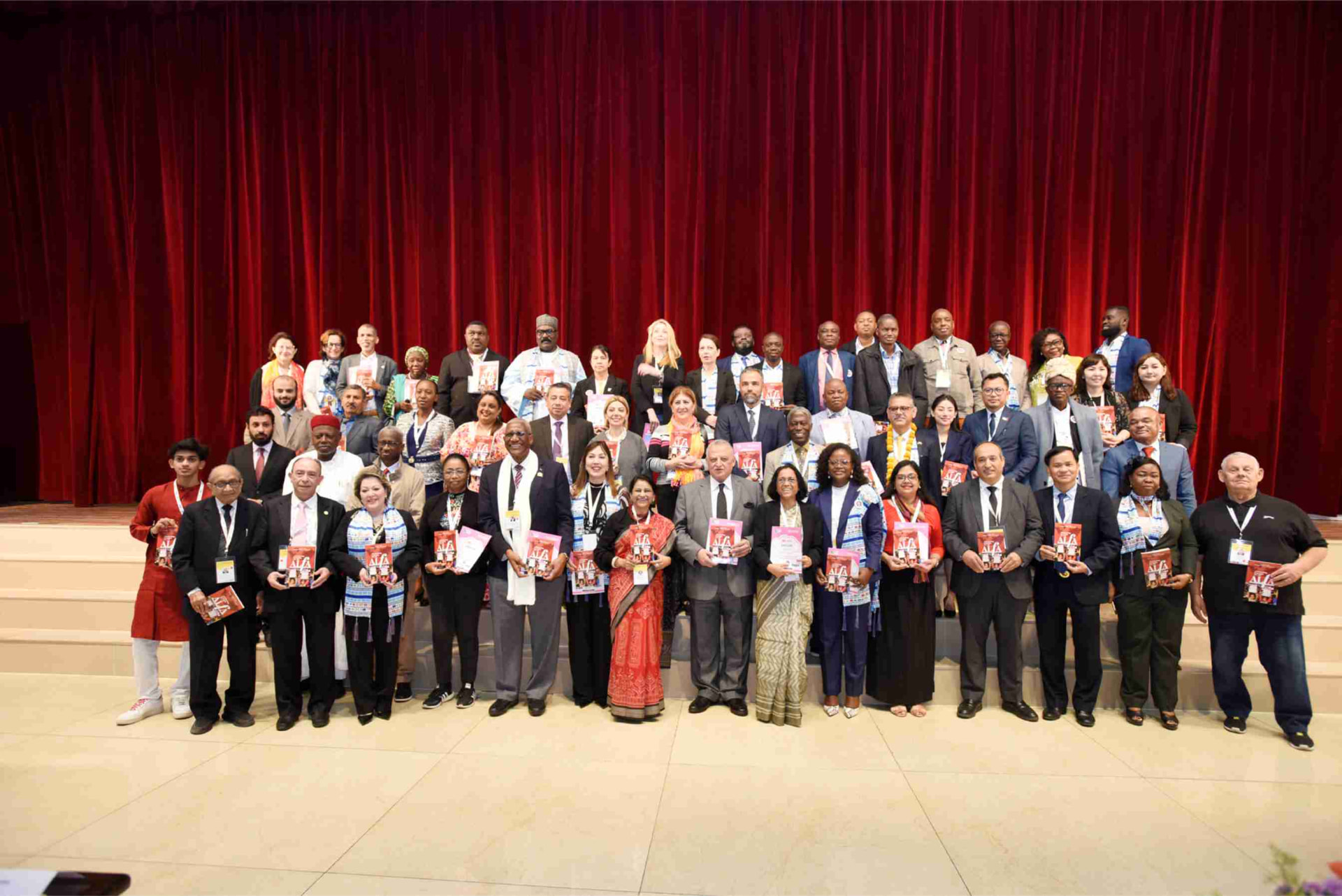International delegates holding ALfA toolkits on stage at a previous convening